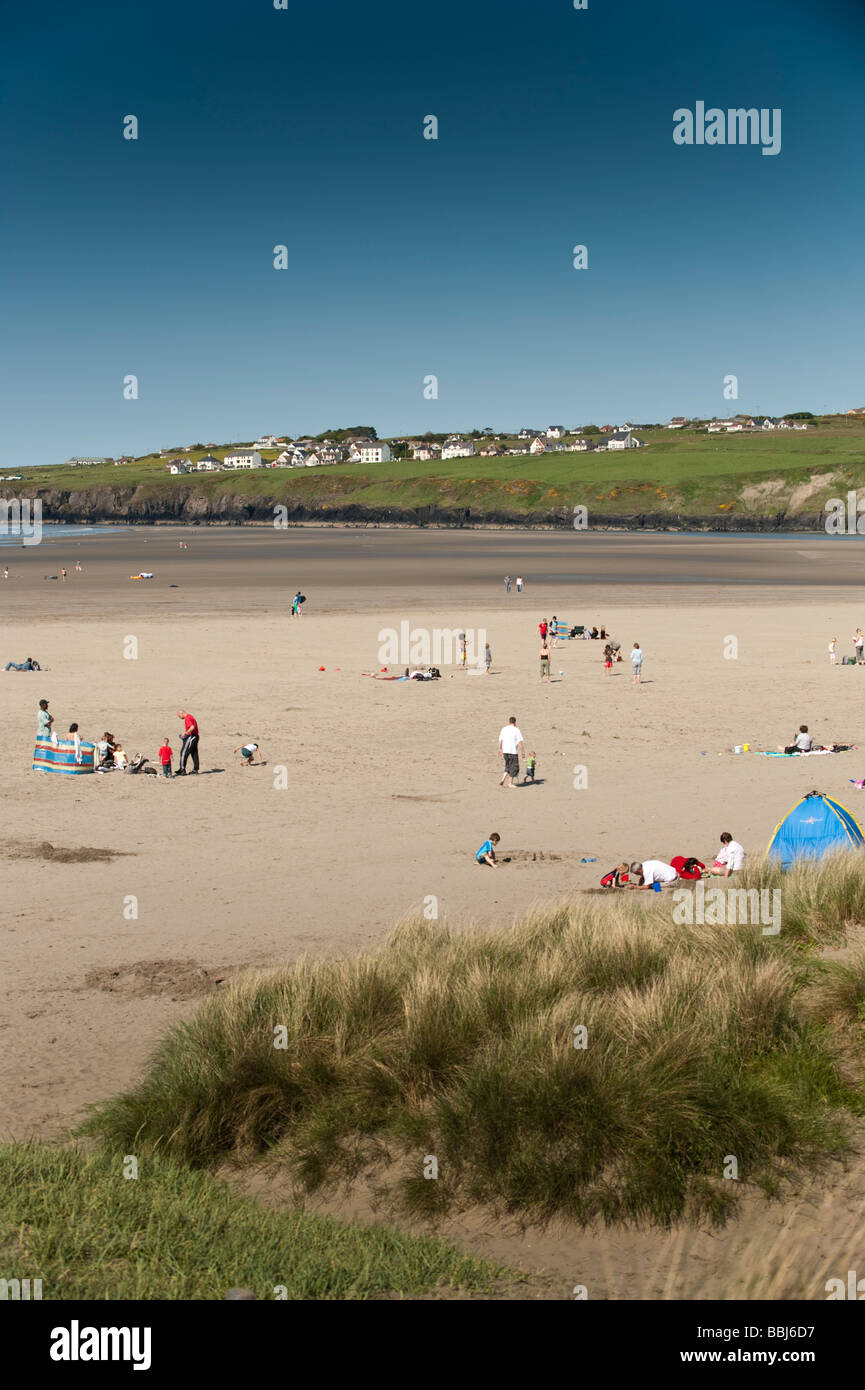 La gente sulla spiaggia sabbiosa, pomeriggio estivo Poppit Sands Beach Parco Nazionale di Pembrokeshire Wales UK Foto Stock