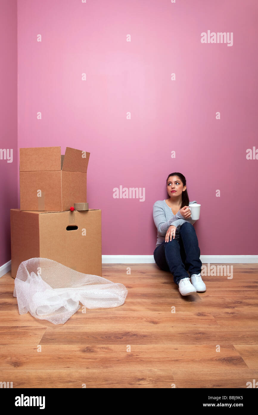 Giovane donna prendendo una pausa da imballaggio durante una casa spostare l'abbondanza di spazio di copia Foto Stock