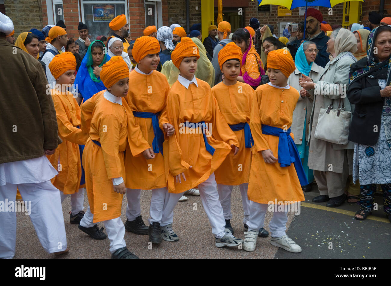 Giovani ragazzi Sikh in ornage per il Vaisakhi processione in Manor Park, Londra. Foto Stock