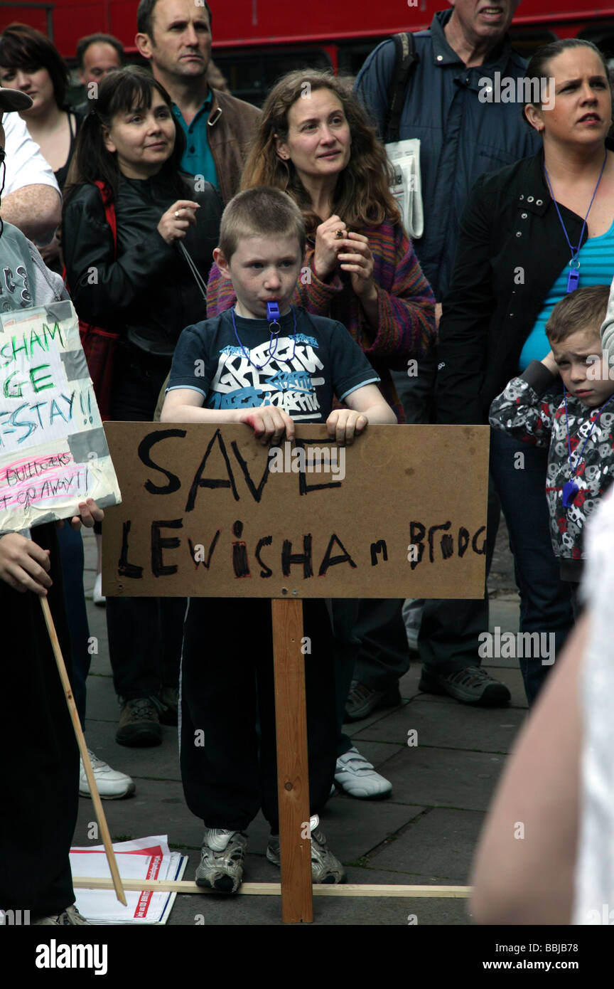 I manifestanti ascoltare con attenzione gli oratori durante una manifestazione contro la demolizione del ponte di Lewisham scuola primaria. Foto Stock