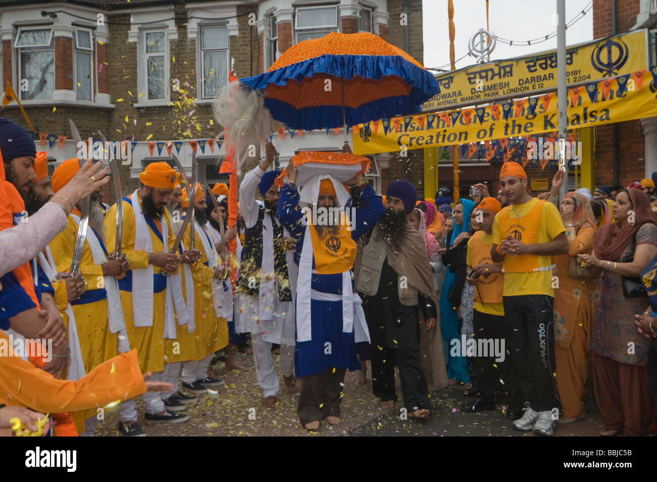 Petali di fiore doccia il Guru Granth Sahib come esso è portato a galleggiante per il Vaisakhi processione in Manor Park, Londra. Foto Stock
