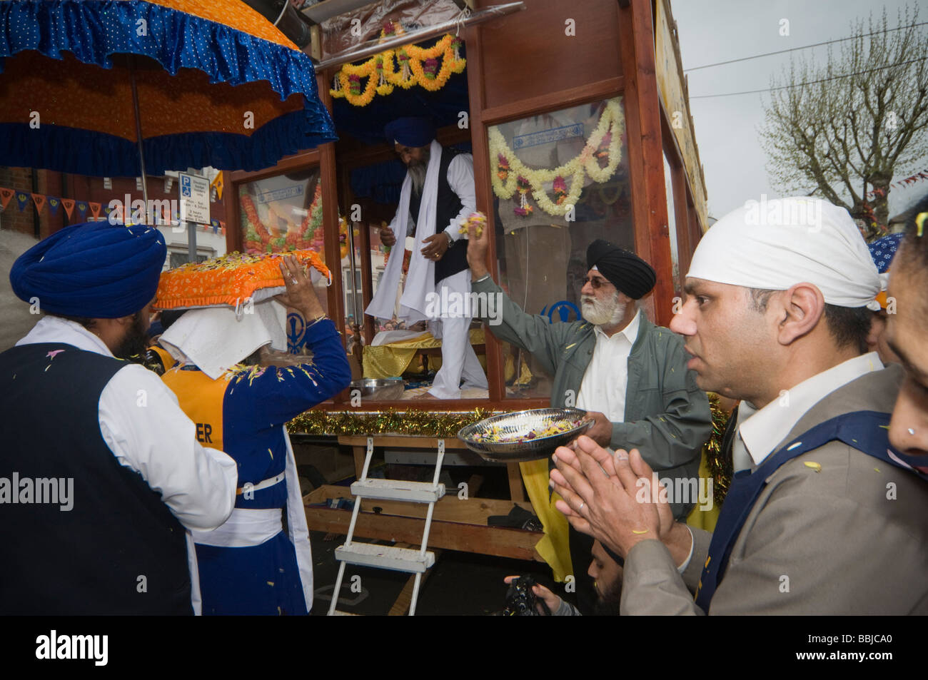 Portando il Guru Granth Sahib al galleggiante per il Vaisakhi processione in Manor Park, Londra. Foto Stock