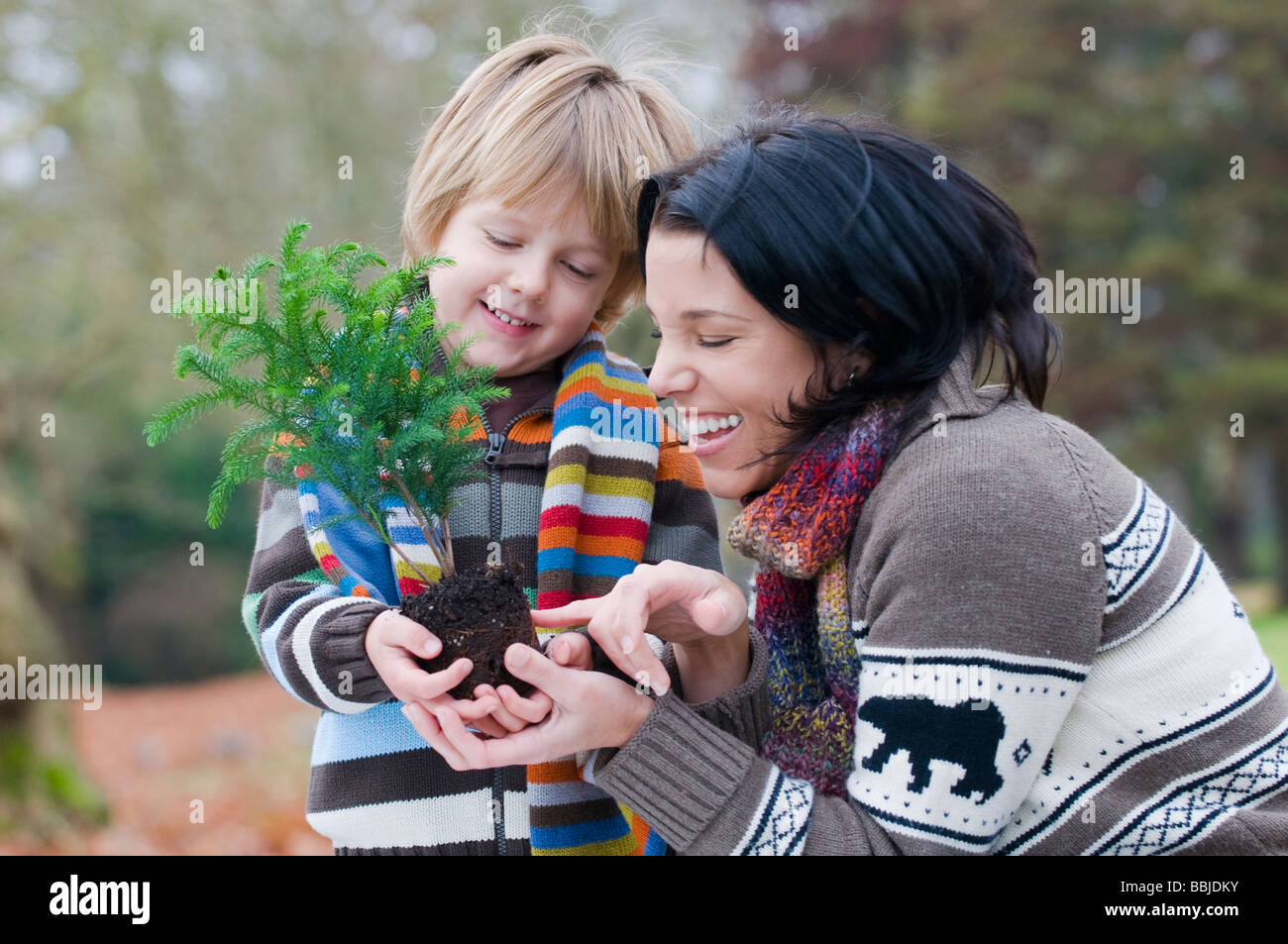 La madre e il ragazzo giovane azienda piccolo albero pronto per impianto, Vancouver, British Columbia Foto Stock