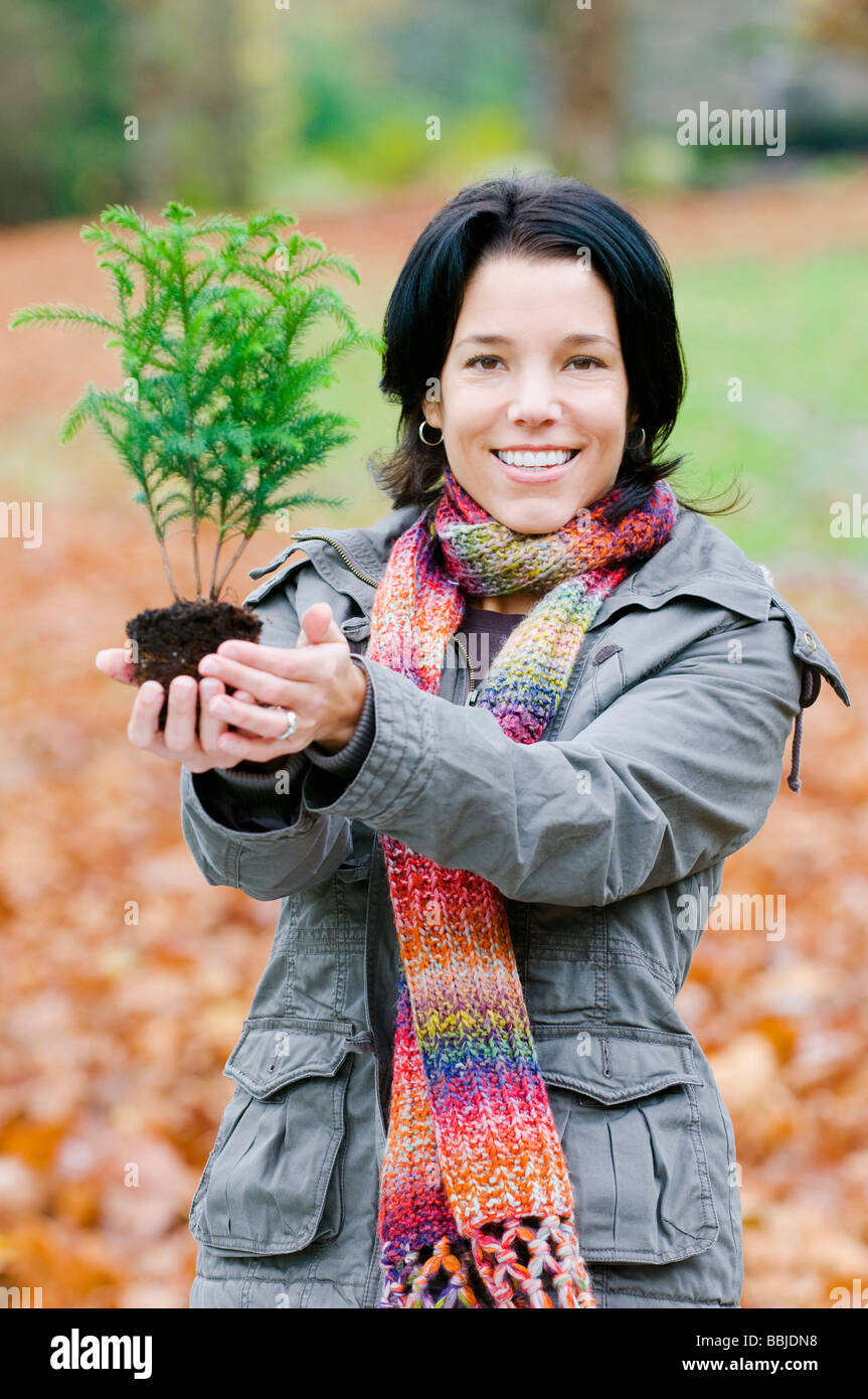 Giovane donna azienda piccolo albero, Vancouver, British Columbia Foto Stock