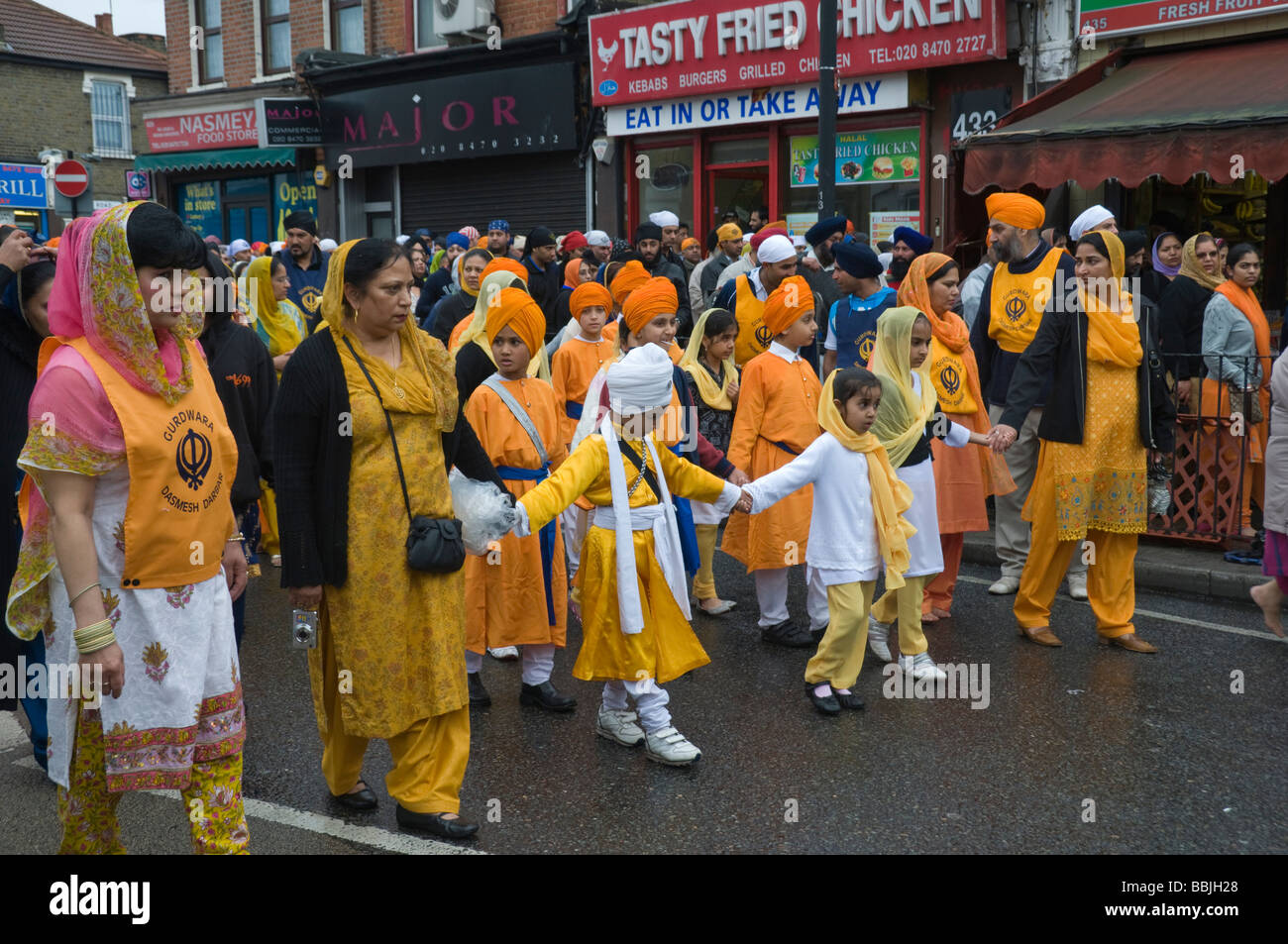 I bambini vestiti in arancione nella Vaisakhi processione in Manor Park, Londra. Foto Stock