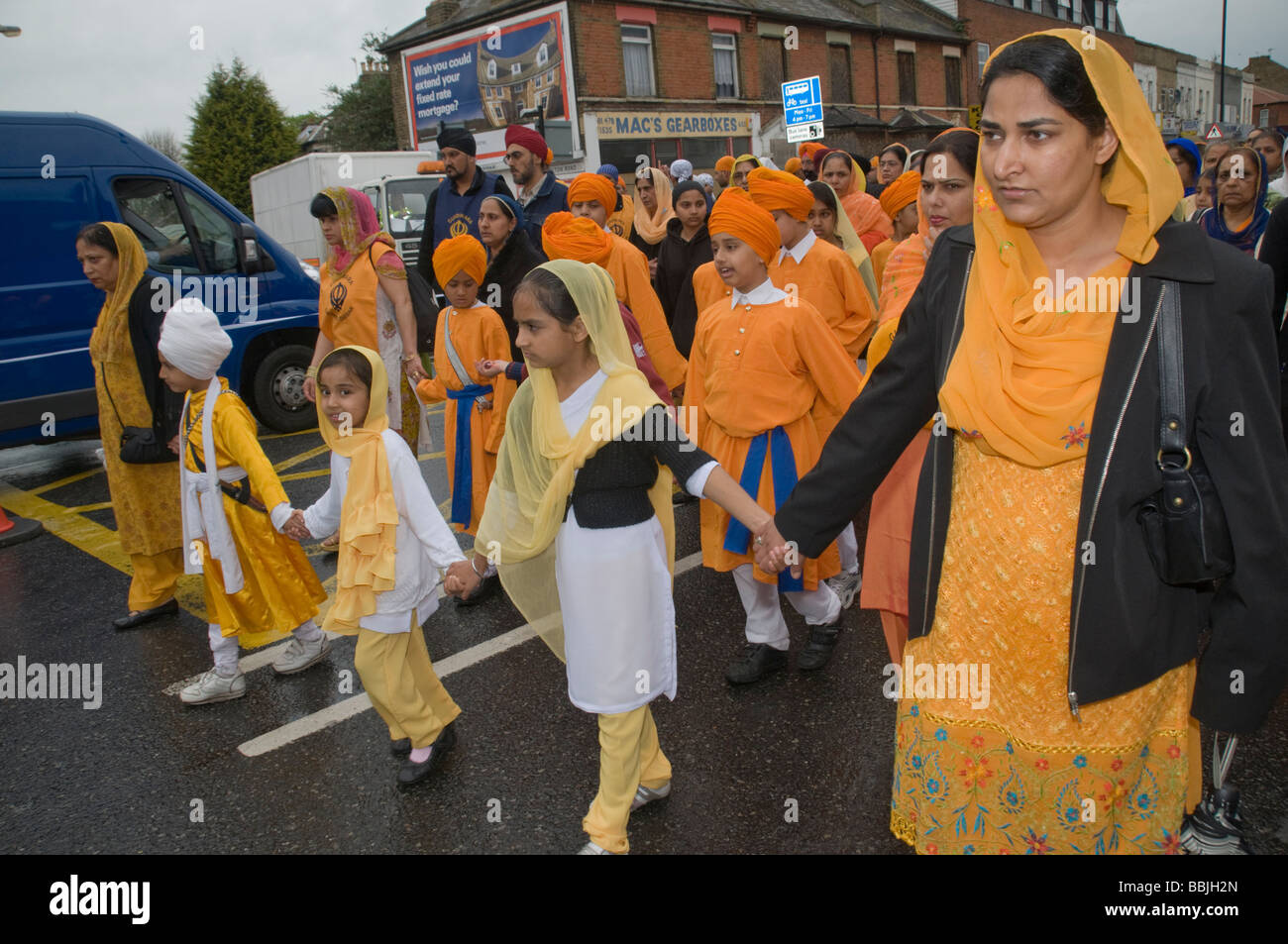 I bambini in arancione prendere parte alla processione Vaisakhi in Manor Park, Londra. Foto Stock