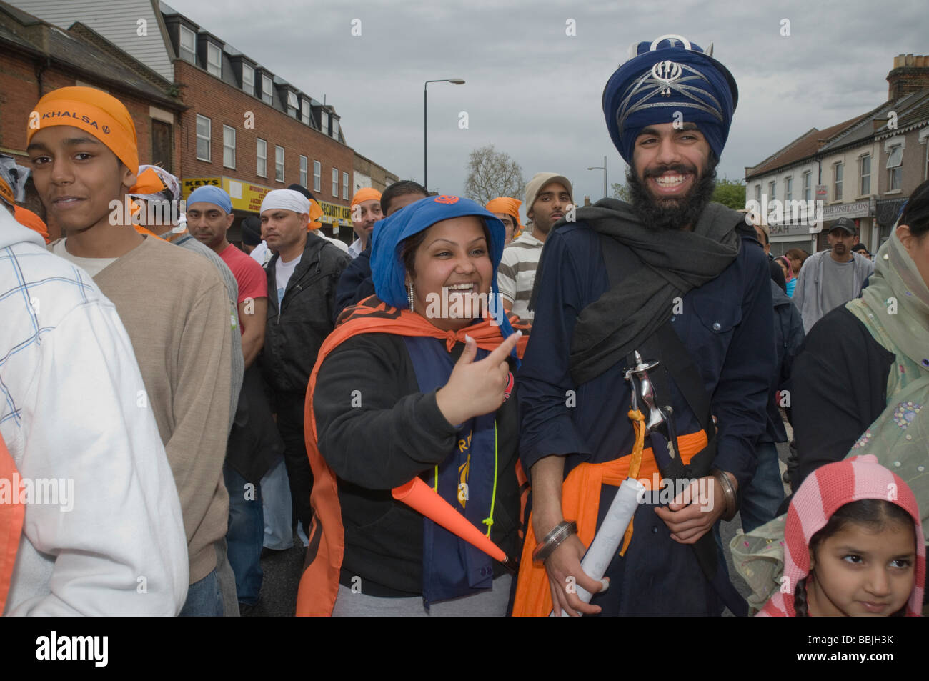 SIhks camminando in processione Vaisakhi in Manor Park, Londra, uomo incluso con elaborato turbante e spada Foto Stock