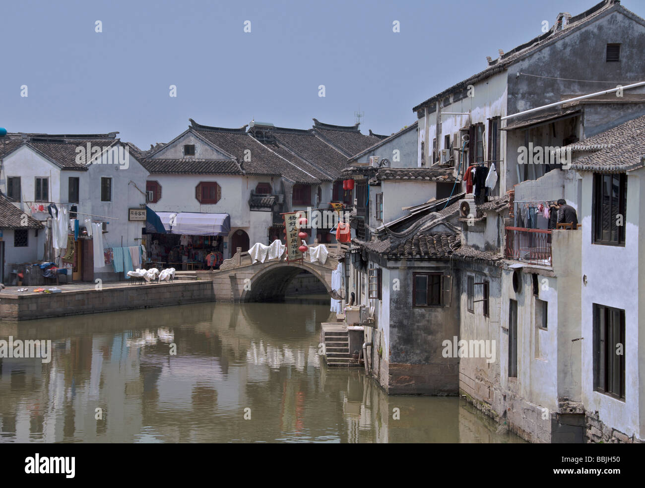 Canal con lavaggio sparsi sul ponte in pietra antica città d'acqua di Tongli Jiansu Cina Foto Stock