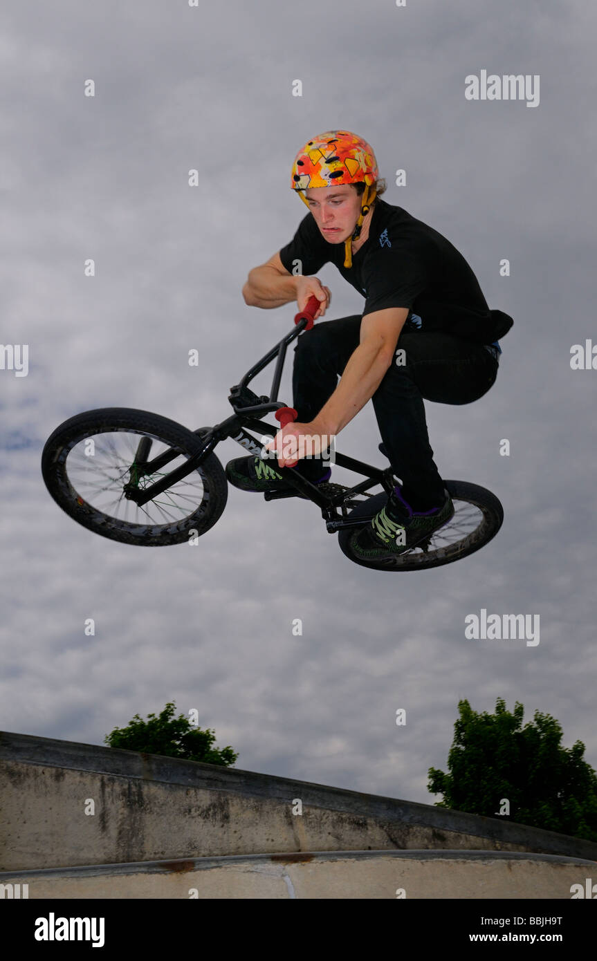 Smorfie bmx bike rider volare in aria facendo un'aria fuori dal piano portapaziente spostare fuori da un muro di cemento a Toronto in Canada Foto Stock