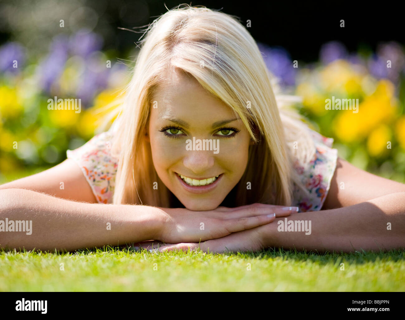 Una giovane donna a godersi il bel tempo in un parco. Foto Stock