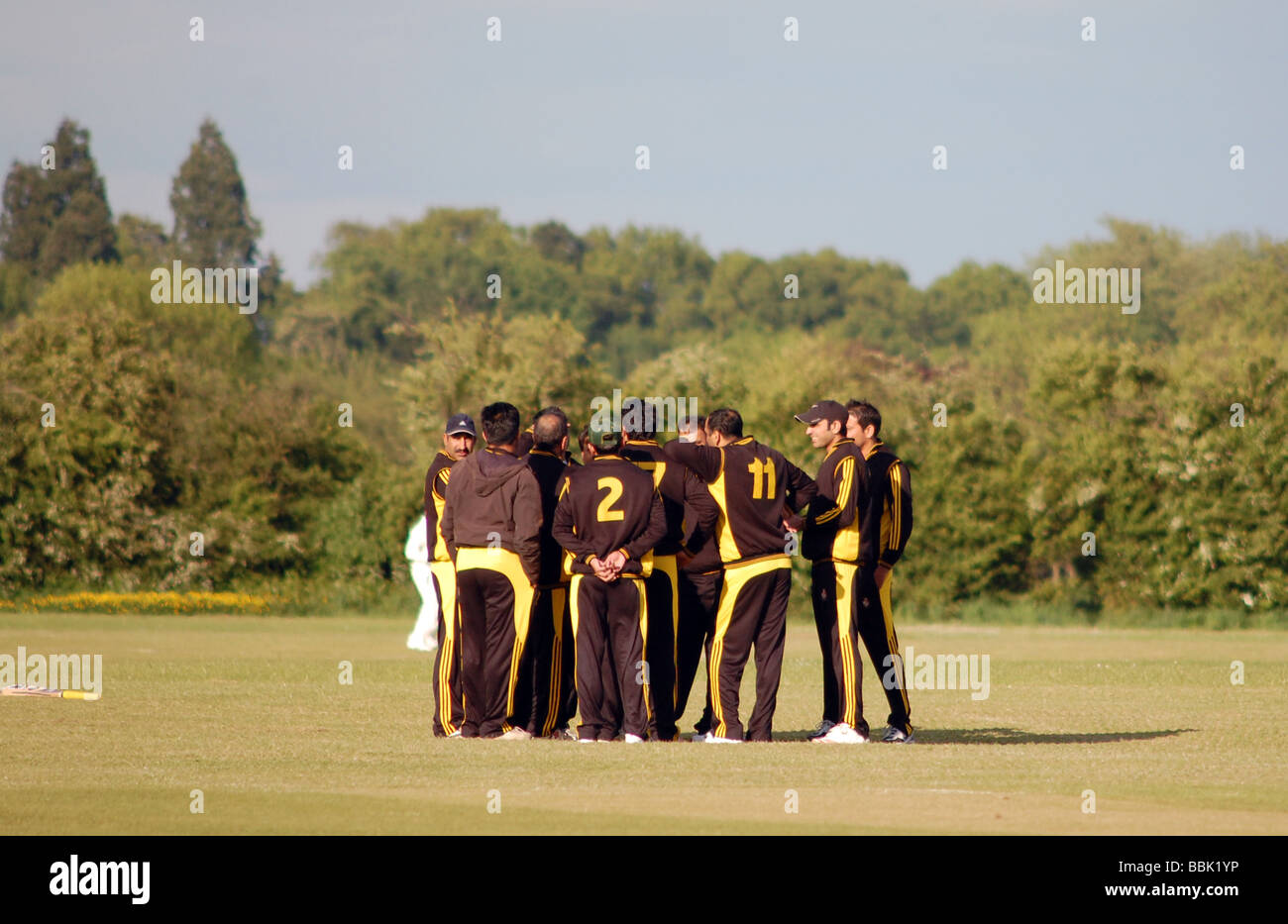 British asian crickters prendere parte in un team-talk in sun. Foto Stock