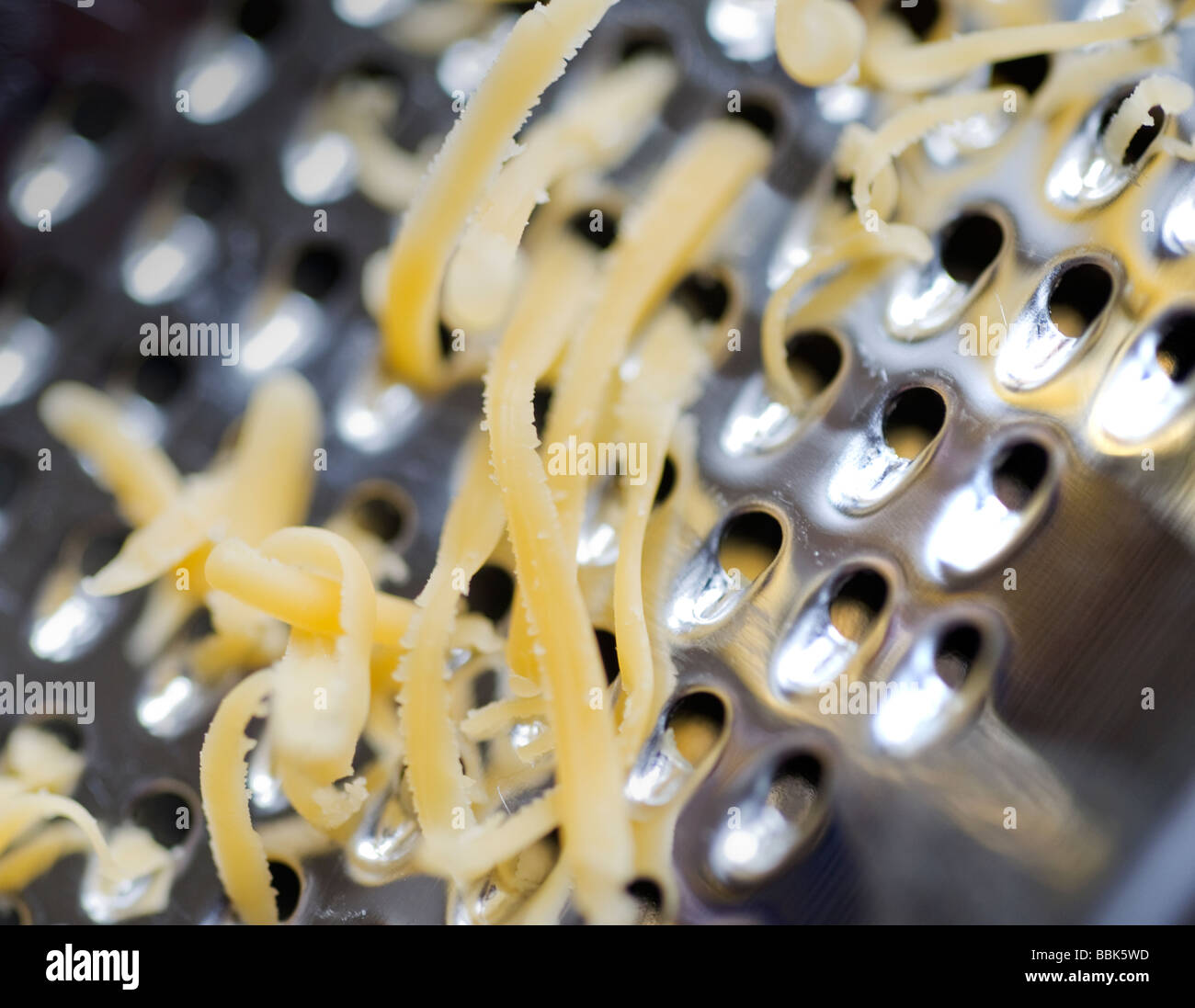 Una chiusura del formaggio grattugiato in corso Foto Stock