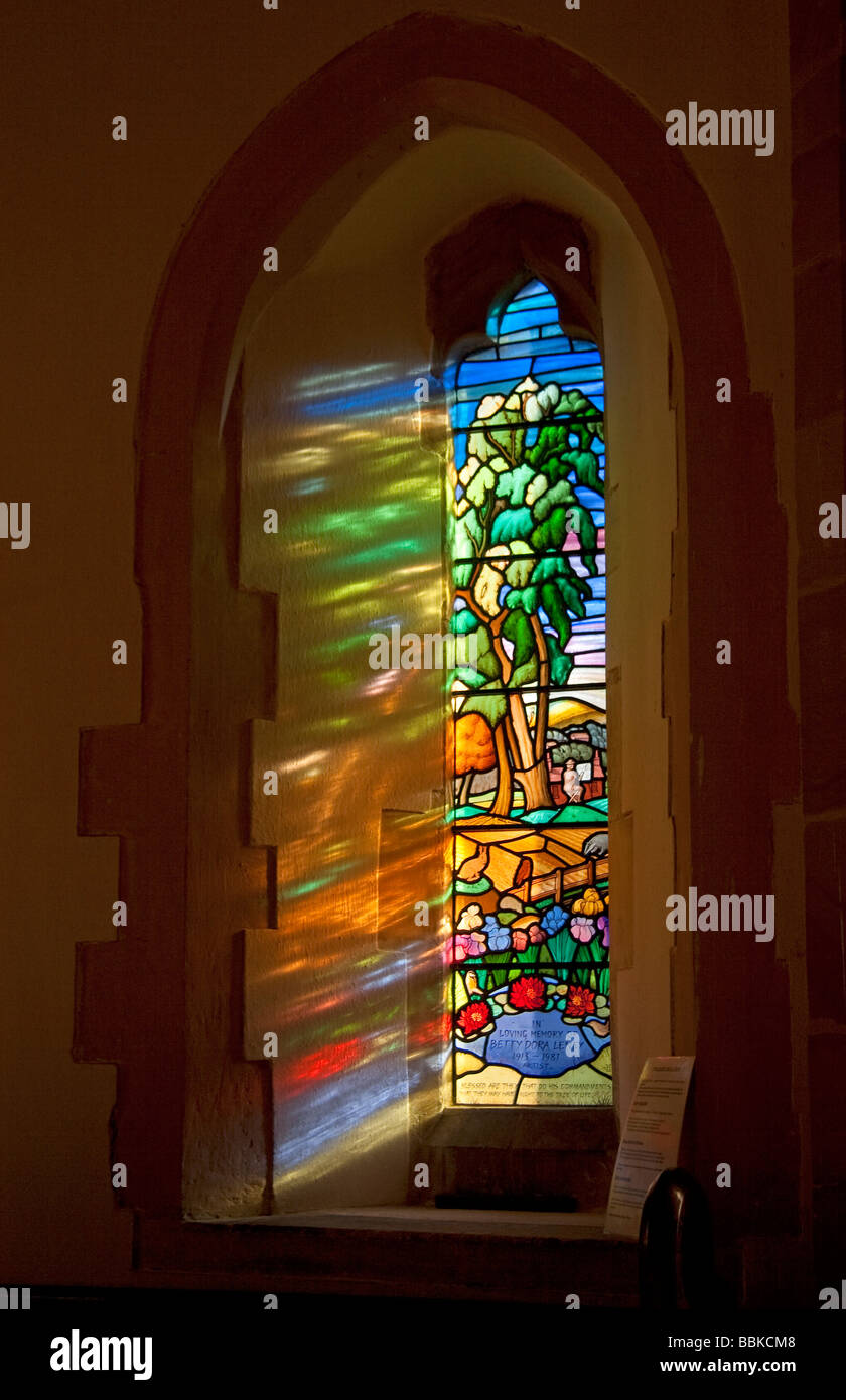Colorato la luce del sole attraverso una finestra di vetro colorato a St Pancras chiesa in Kingston nelle vicinanze del Lewes villaggio in East Sussex Foto Stock