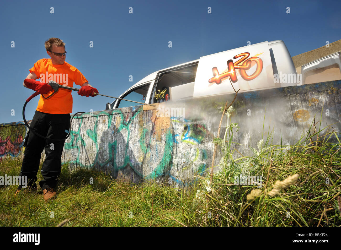 Un uomo che pulisce graffiti a Brighton Marina utilizzando acqua calda pressurizzata Foto Stock