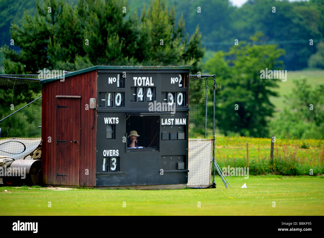 Una donna osserva i punteggi verso il basso a livello locale partita di cricket in cuckfield Foto Stock