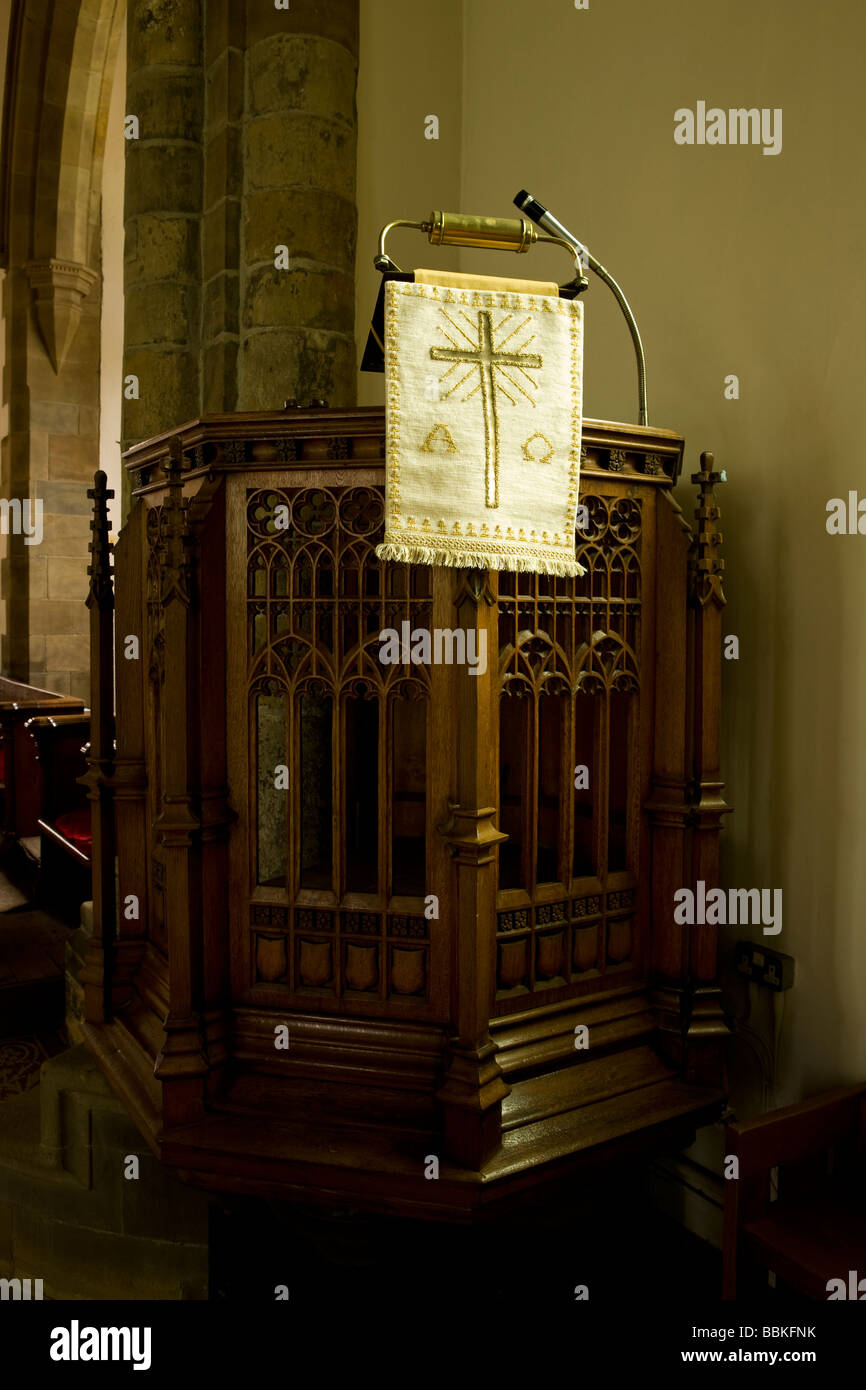 Il pulpito in un inglese chiesa parrocchiale con microfono e croce in oro Foto Stock