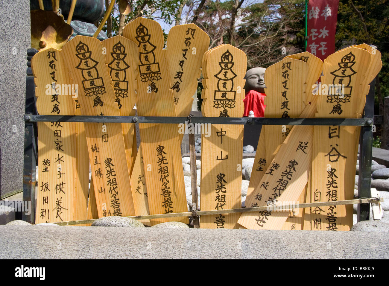 Primo piano delle schede ema giapponesi in legno impilate su binari metallici. Ogni compressa ha un'illustrazione di cinque pagoda di pietra. Tempio Matsudaisan, Kinosaki Foto Stock