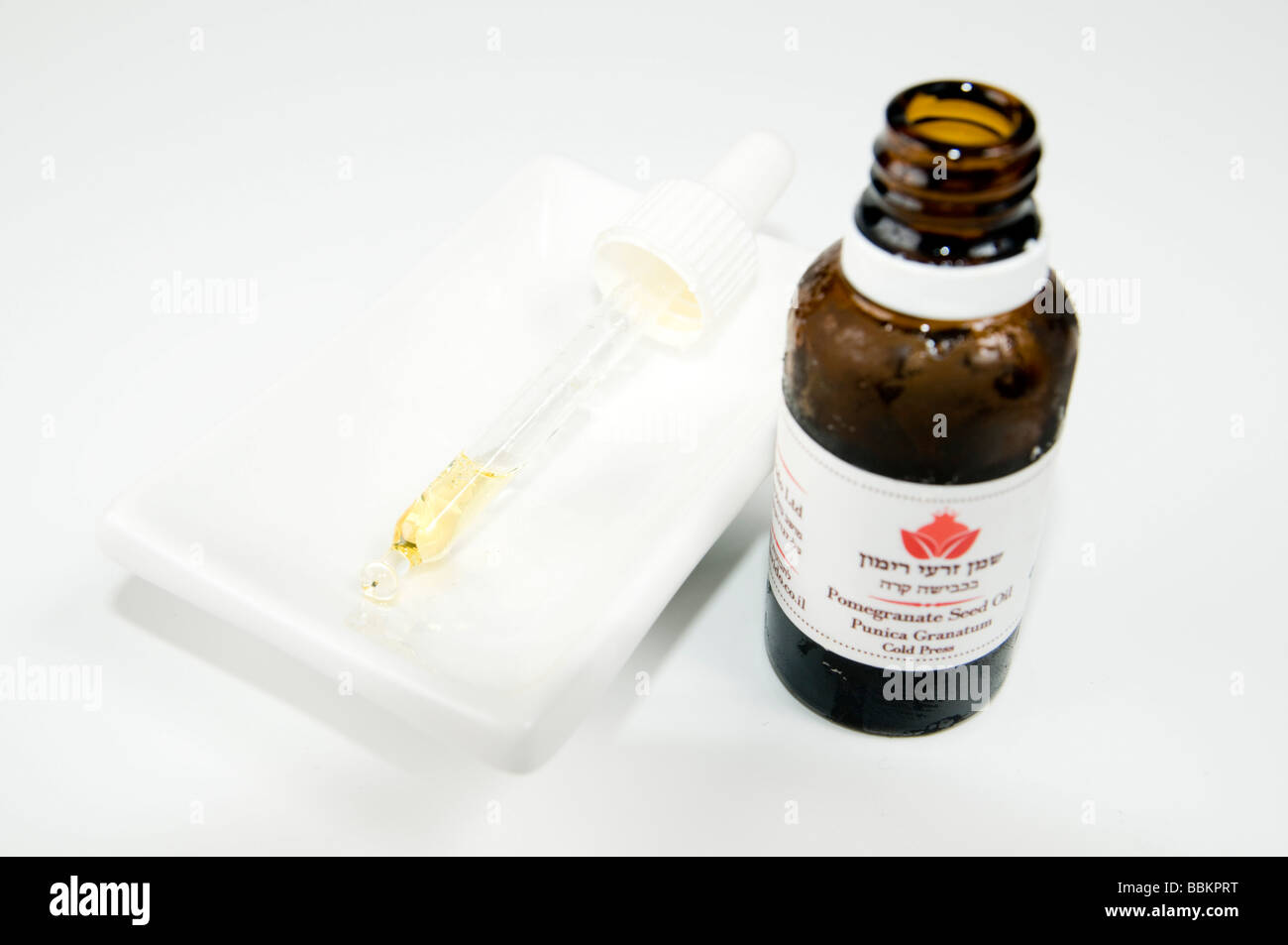 Spaccato di melagrana olio di seme Punica granatum su sfondo bianco Foto Stock