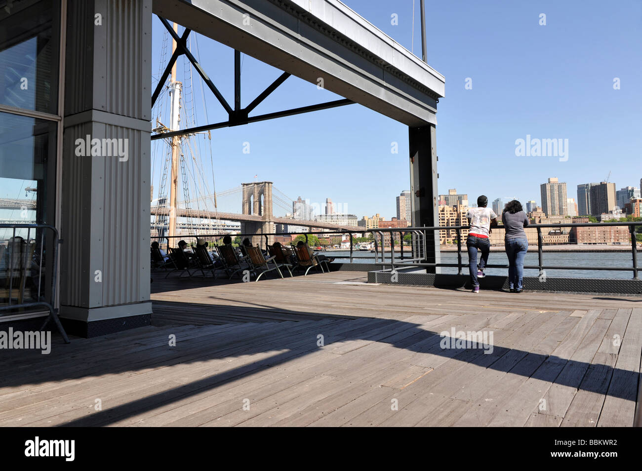 I turisti al South Street Seaport, Pier 17, ammirando lo skyline di Brooklyn Foto Stock