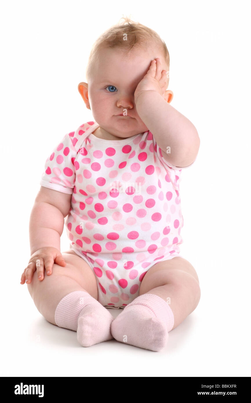 Little Baby girl copre il suo occhio con la mano sinistra isolato su bianco con ombra Foto Stock