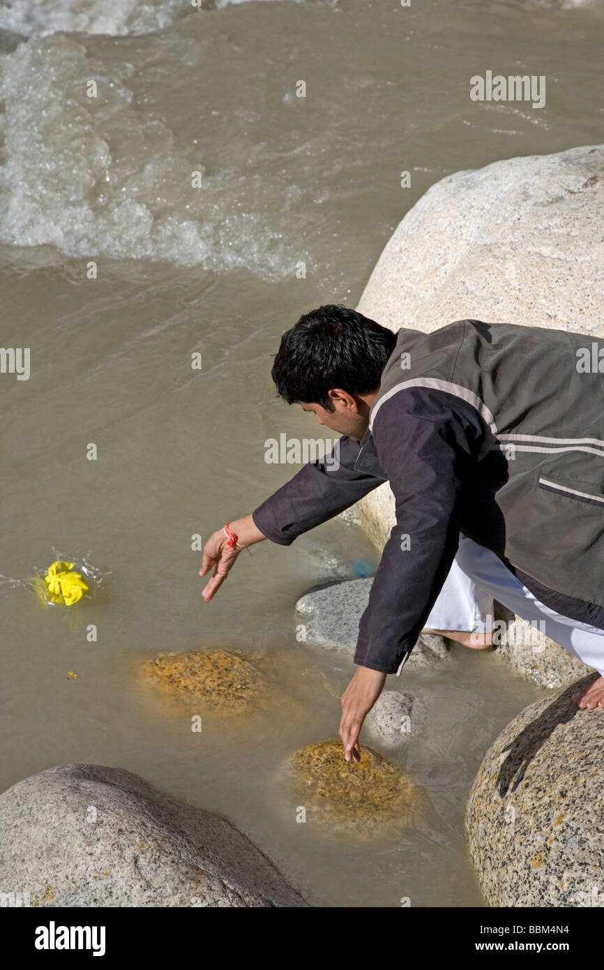 Padre offrendo i peli rasati di suo figlio il Gange fiume (cerimonia Mundan). Gangotri. Uttarakhand. India Foto Stock