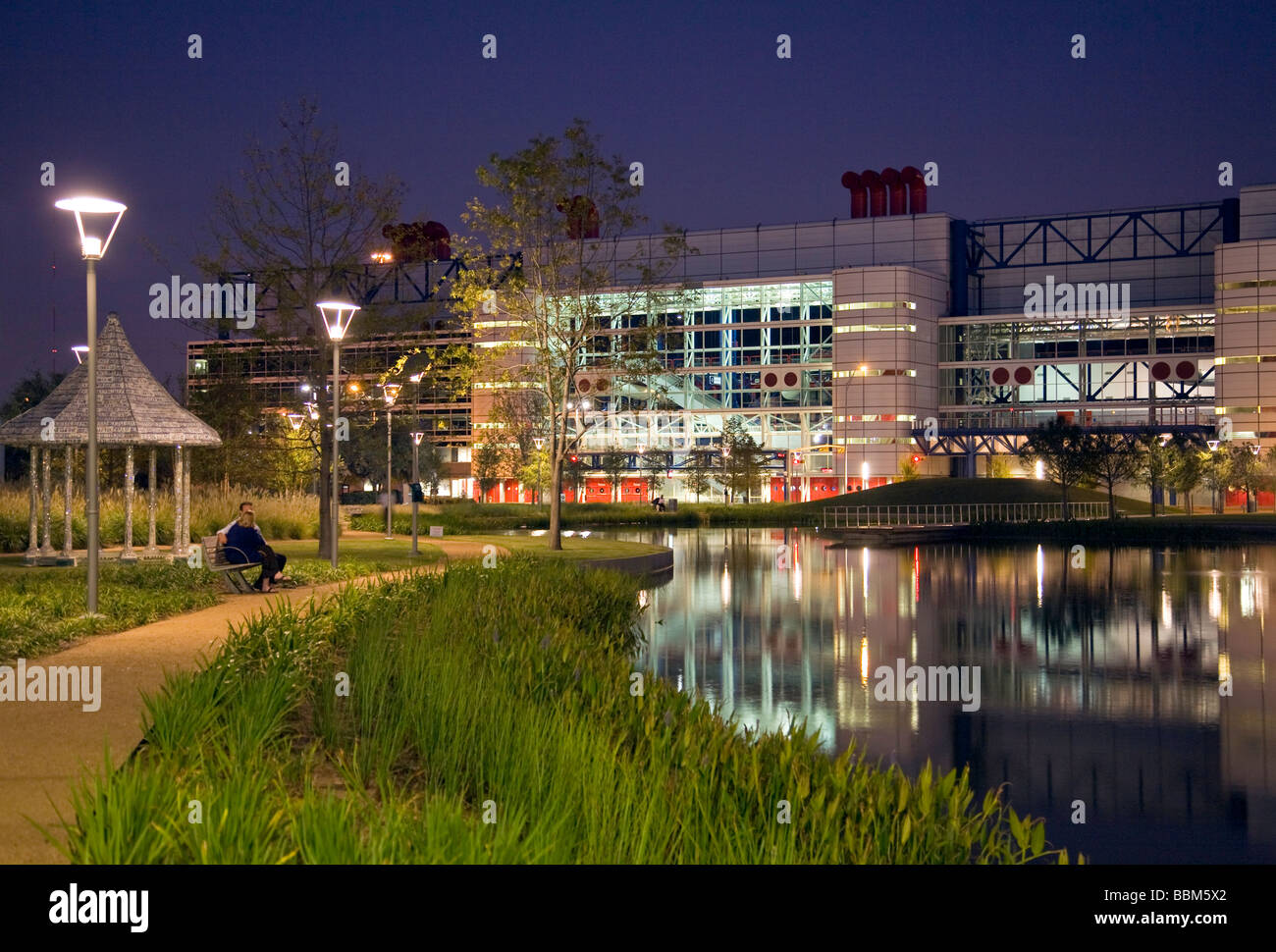 Houston, TX, Stati Uniti d'America: la città il George R. Brown Convention Center si accende al crepuscolo, come si vede da Discovery Green park. Foto Stock