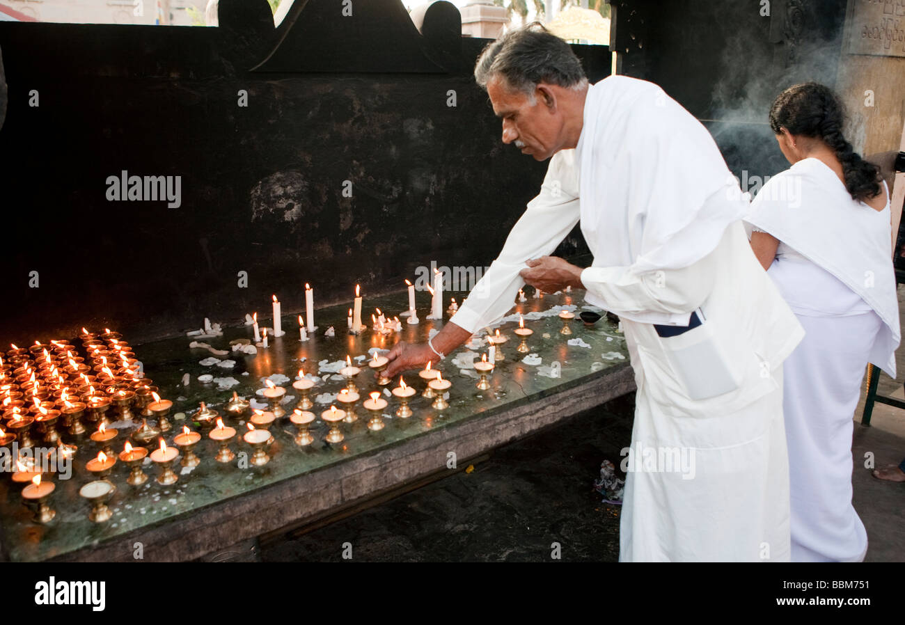 Un uomo accendendo candele a Mulgandha Vihar Tempio Sarnath Varanasi Uttar Pradesh, India Foto Stock