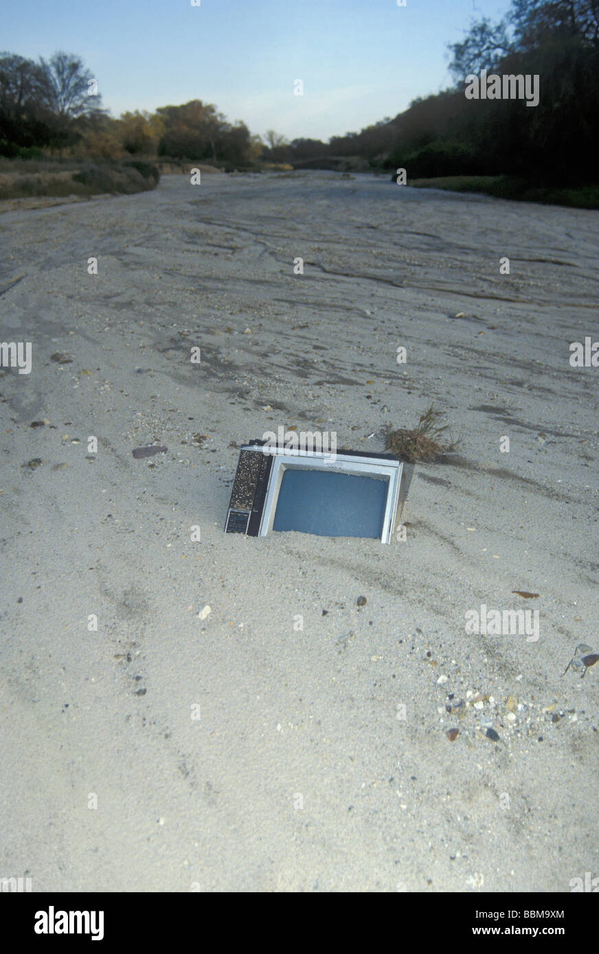 Un televisore è mezzo sepolto nella sabbia di un lavaggio dopo un allagamento Foto Stock