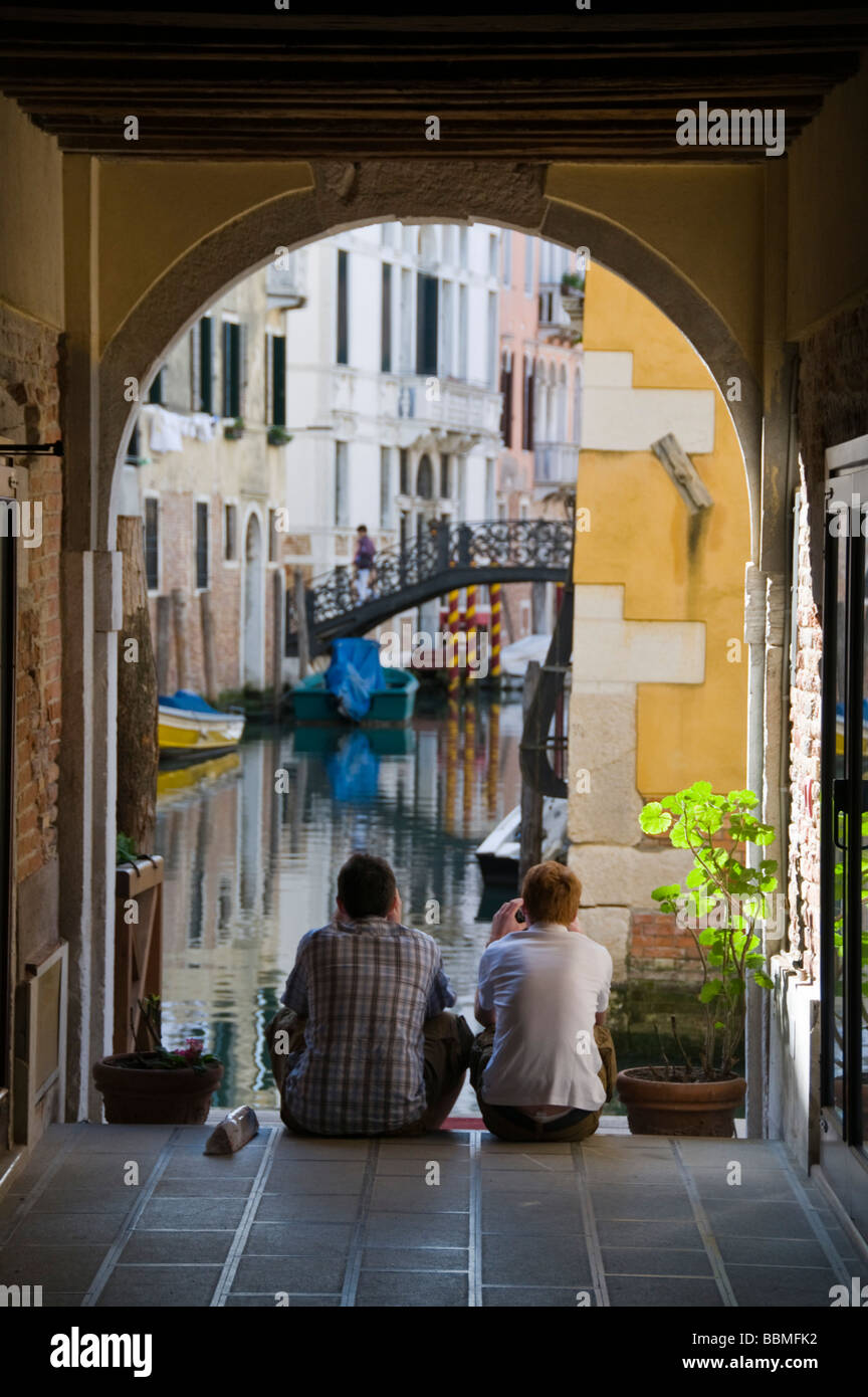 Due uomini guardando il piccolo canale Venezia Italia Foto Stock