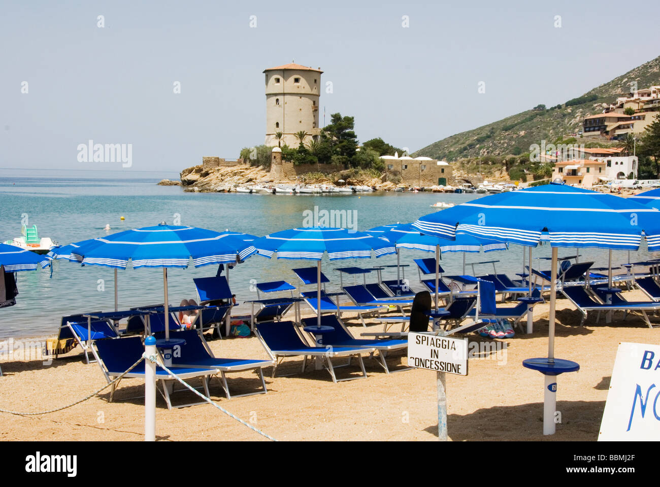 Blue ombrelloni e lettini per prendere il sole in una parte privata del Giglio Campese la spiaggia principale dell'isola del Giglio Foto Stock