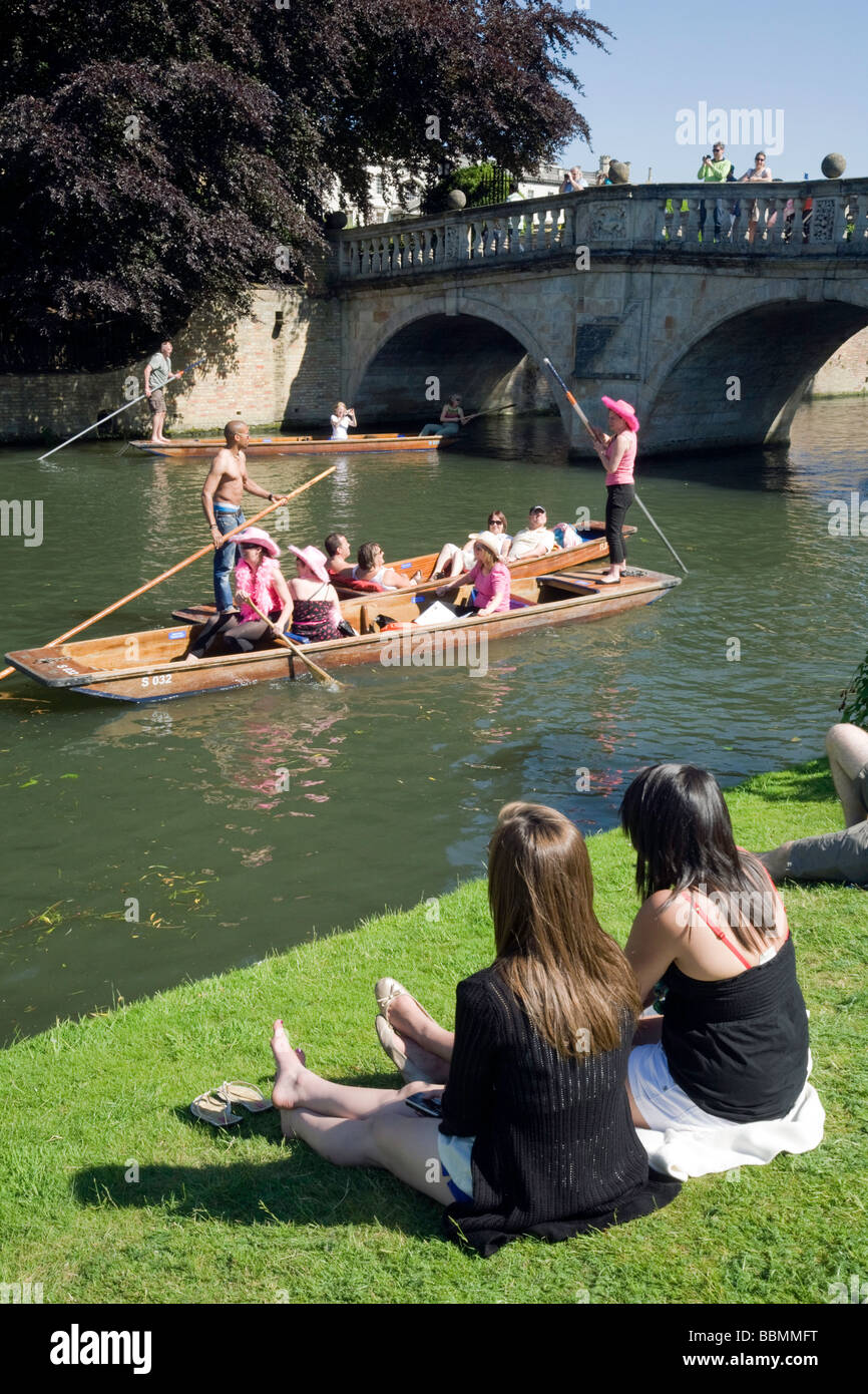 La gente seduta sulle sponde del fiume Cam a Clare College di Cambridge, guardando il punting su una giornata d'estate Foto Stock