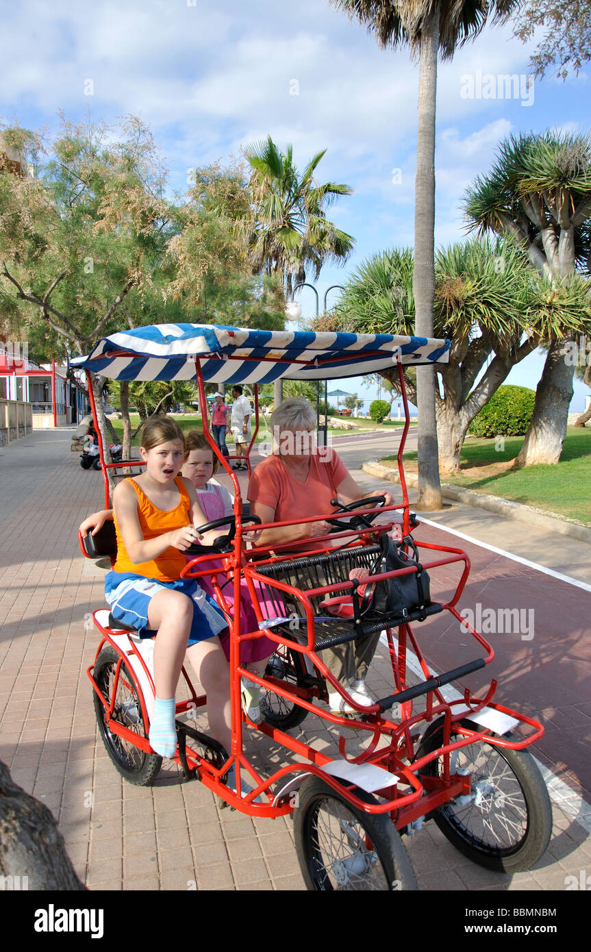 La famiglia sul moto del pedale. beach promenade, Cala Millor, a Sant Llorenç des Cardassar comune, Maiorca, isole Baleari, Spagna Foto Stock
