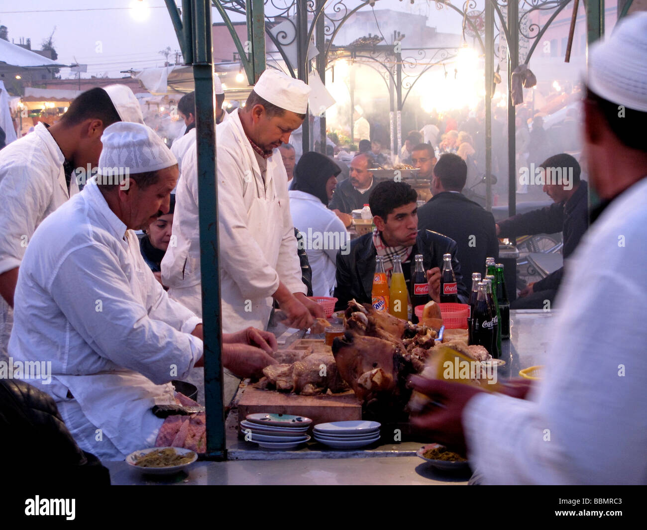 La cottura di carne di maiale nel souk di Marrakech marocco Foto Stock