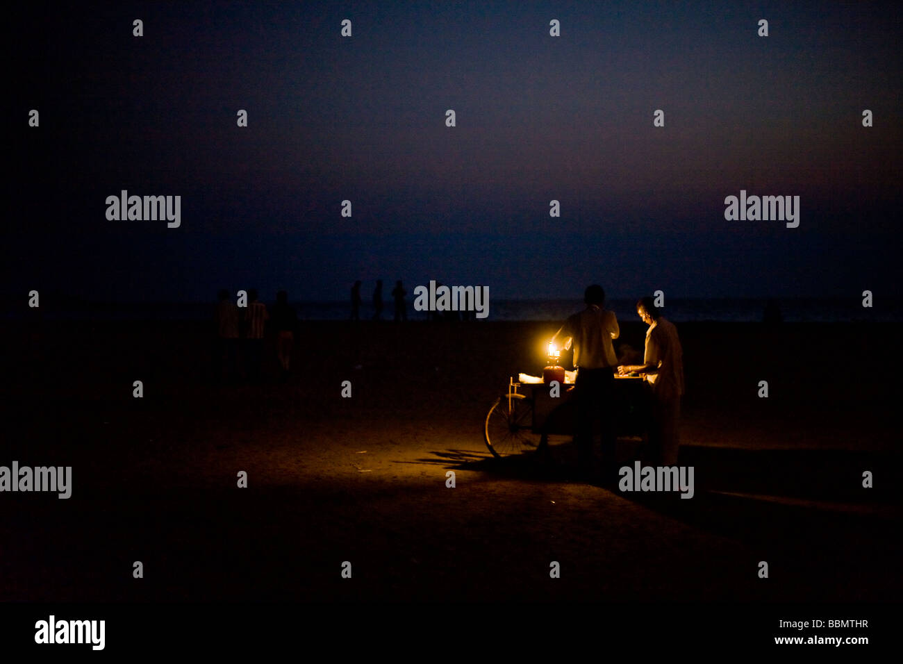 Indian venditore ambulante di vendita di alimenti sulla spiaggia al tramonto. Foto Stock