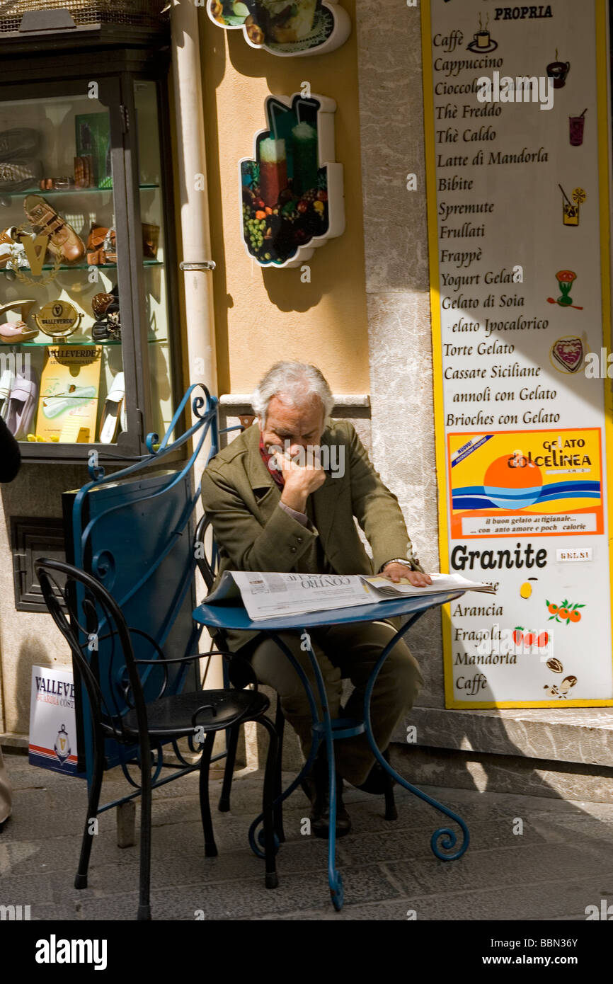 Uomo in cafe di sul Corso Umberto da Piazza IX Aprile Taormina Sicilia Foto Stock