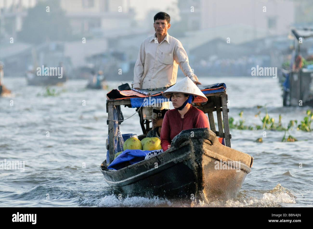 L'uomo e di una donna con un cappello vietnamita, trading barca sul fiume Mekong, Delta del Mekong, Vietnam Asia Foto Stock