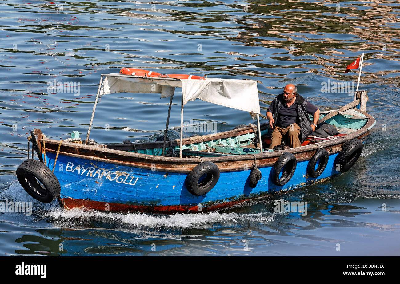 L'uomo manzi pittoresca barca di legno per i passeggeri sul Golden Horn, Istanbul, Turchia Foto Stock