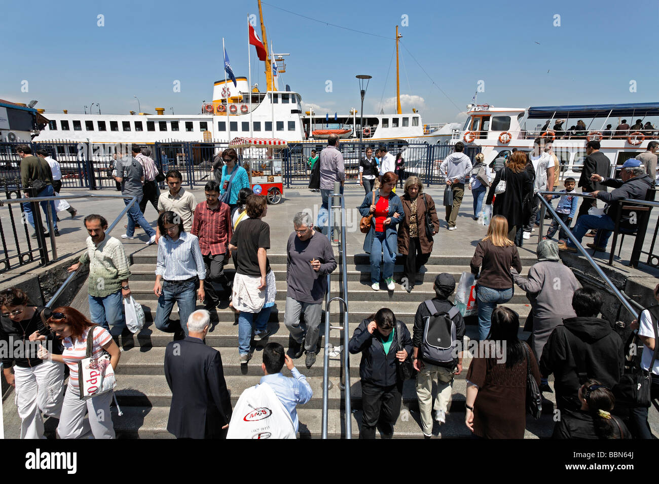 Scale dal tram al terminale del traghetto Eminoenue, gremito di gente, Istanbul, Turchia Foto Stock