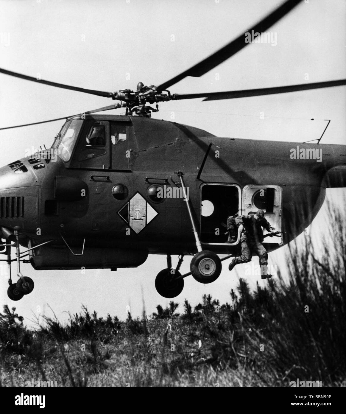 Militare, Germania orientale, Esercito Popolare nazionale, forze terrestri, esercizio, soldato di un'unità di ricognizione che salta da un elicottero Mil Mi-4 'Hound', 1968, Foto Stock