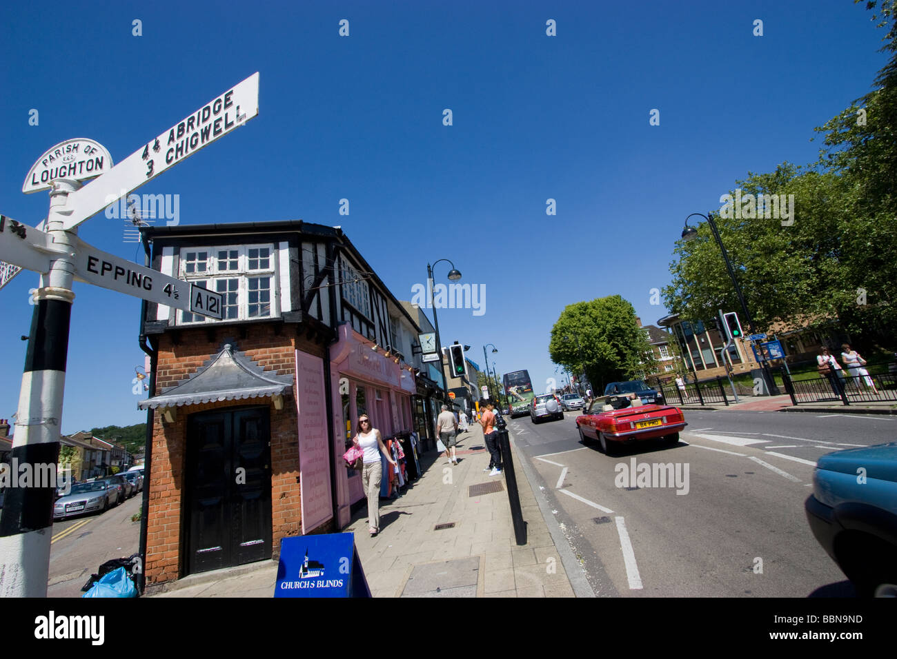 Gli amanti dello shopping a Loughton High Road Essex, scena di strada con cartelli storici Foto Stock