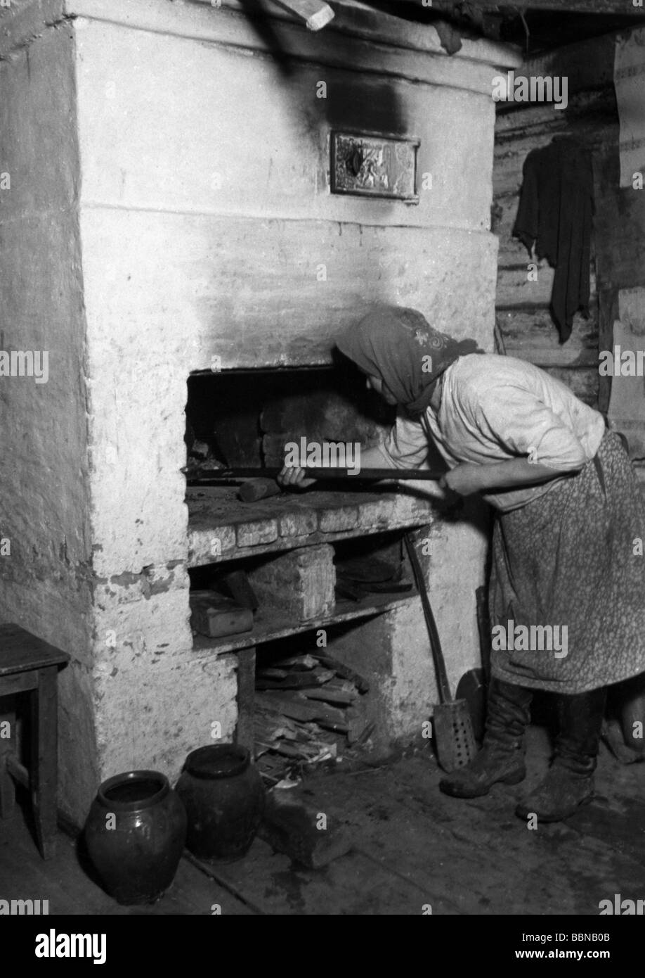 Geografia / viaggio, Russia, popolo, donna contadina russa al forno della sua casa, Sytshevka vicino Smolensk, autunno 1941, Foto Stock