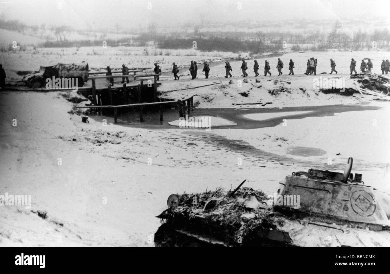 Eventi, Seconda guerra mondiale / seconda guerra mondiale, Russia 1944 / 1945, fanteria tedesca che marciano in un'area di assemblaggio per un contrattacco, vicino Britskoye, Ucraina, fine gennaio 1944, in primo piano un carro armato sovietico T-34/76 abbattuto, Foto Stock