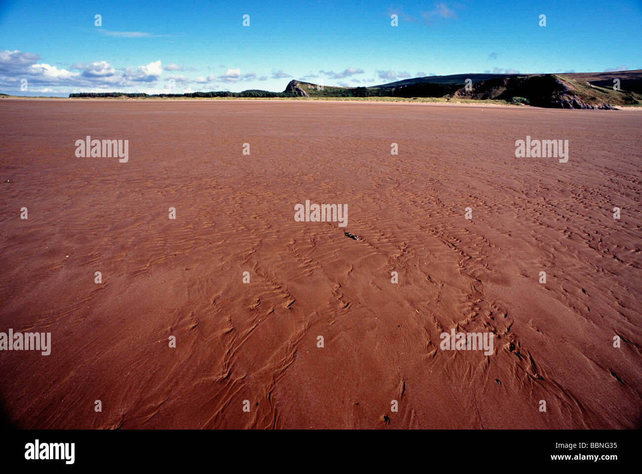 Ampia spiaggia di sabbia con le colline in background Foto Stock