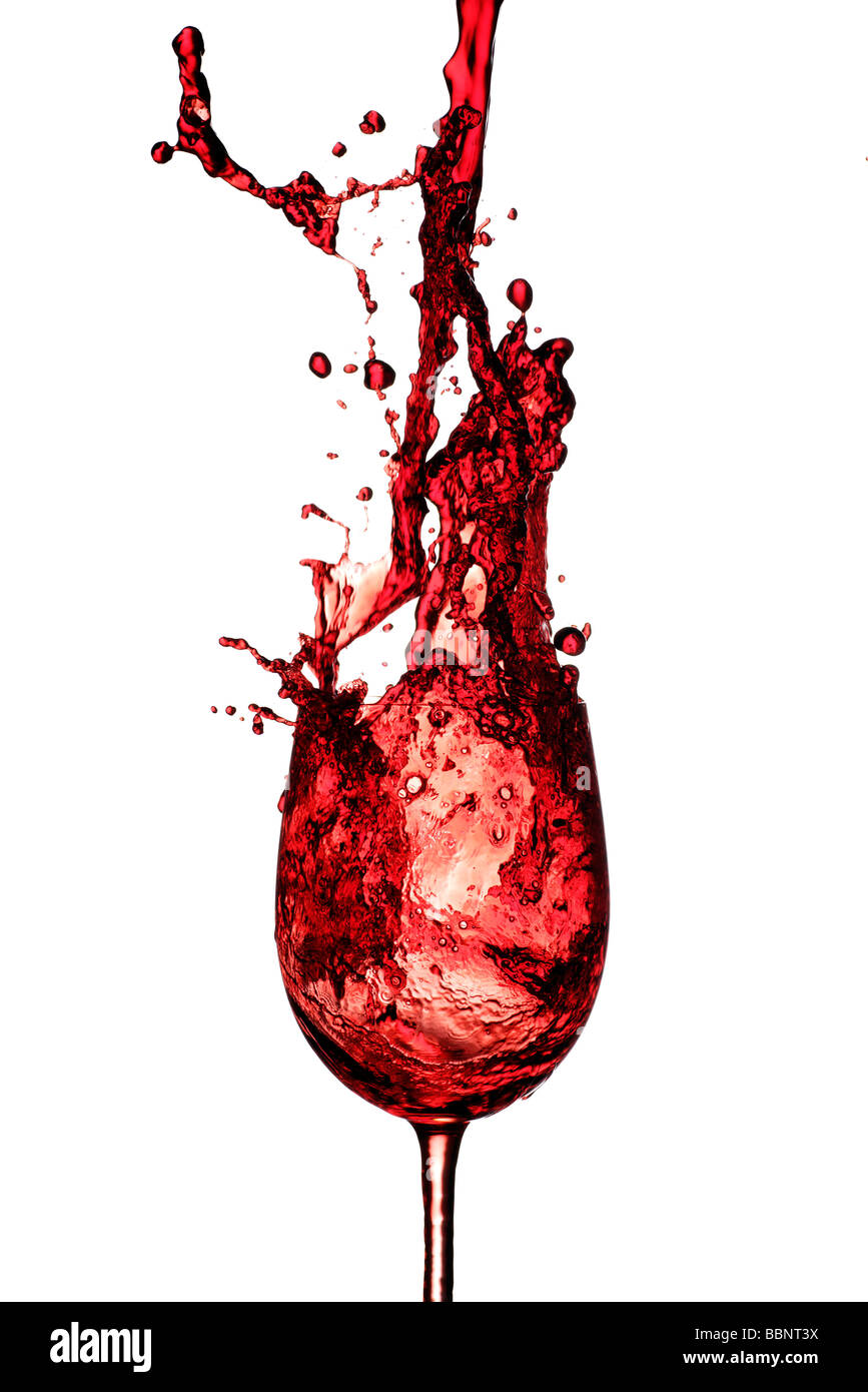 Vino rosso che viene versato in un bicchiere di vino da un'altezza Foto Stock