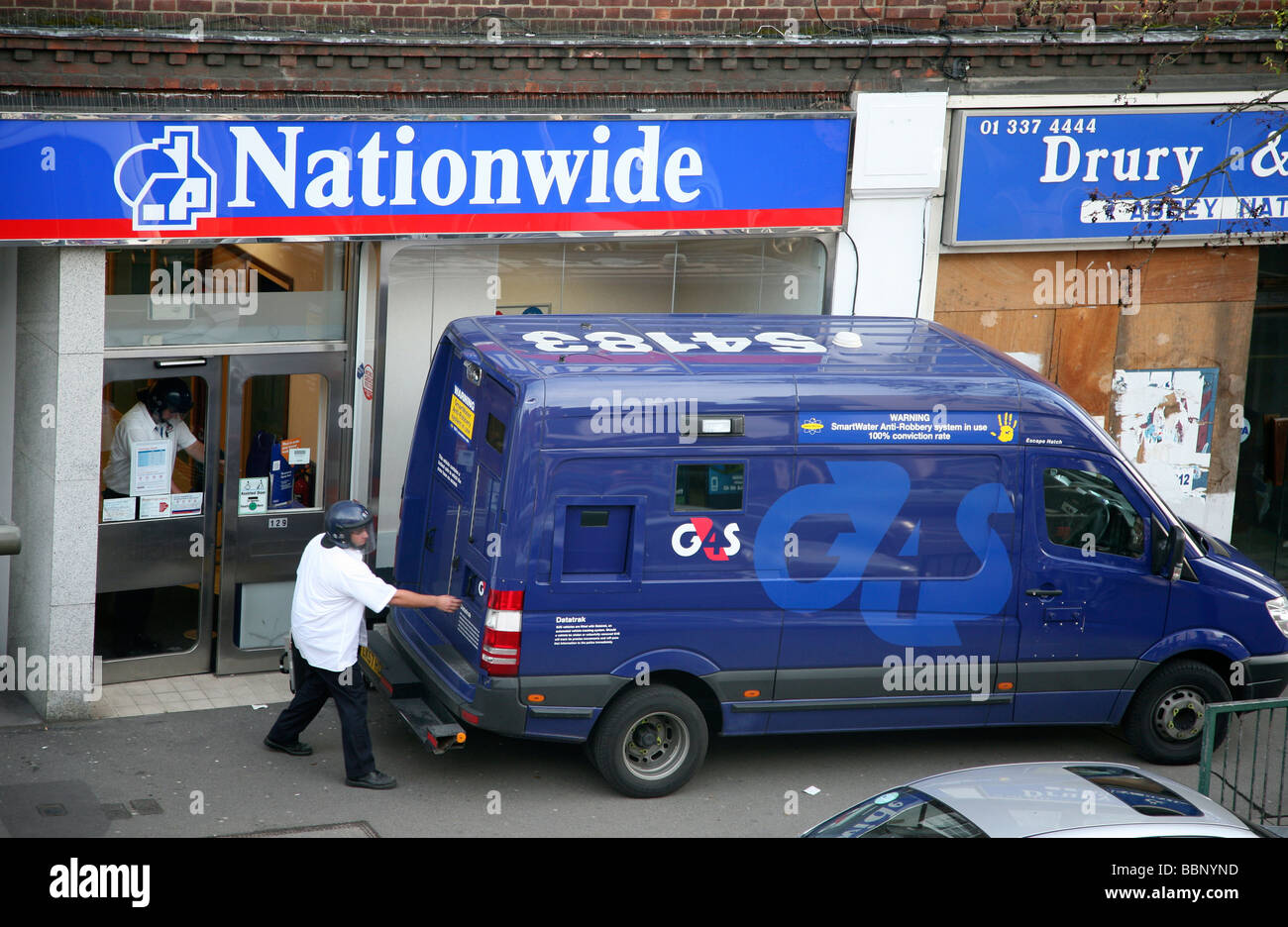 La guardia di sicurezza inserendo la parte posteriore di un gruppo di sicurezza 4 van con il denaro dalla nationwide building society. Foto Stock