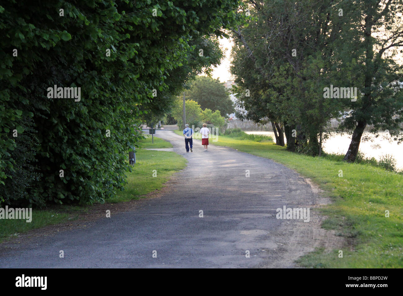 Pensionati anziani matura fate una passeggiata lungo le sponde del fiume al crepuscolo in Charente area della Francia. Foto Stock