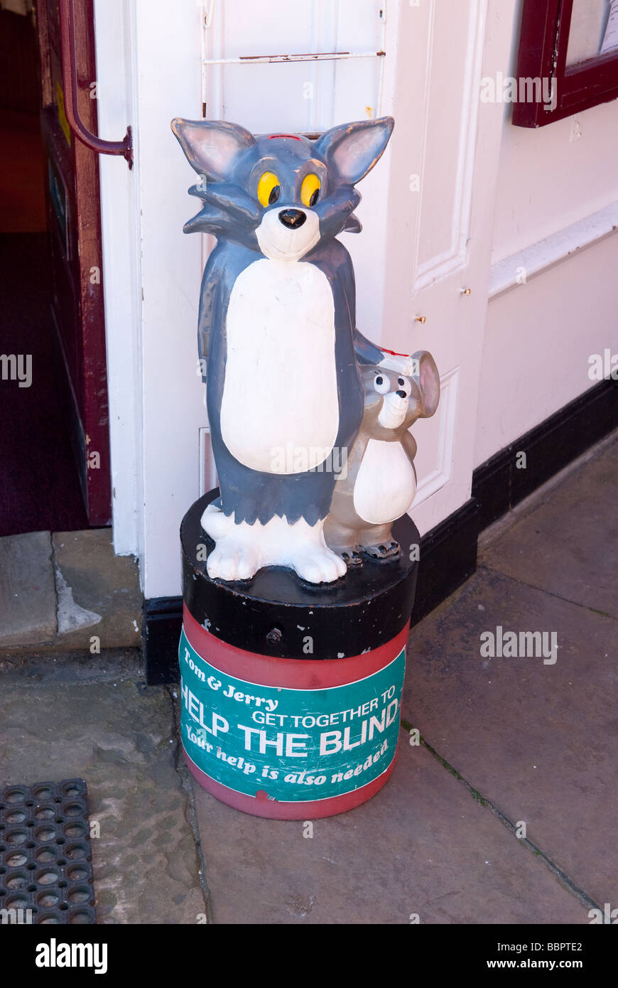 Una scatola di beneficenza in aiuto di aiutare i non vedenti con i personaggi dei cartoni animati Tom & Jerry sulla parte superiore nel Regno Unito Foto Stock