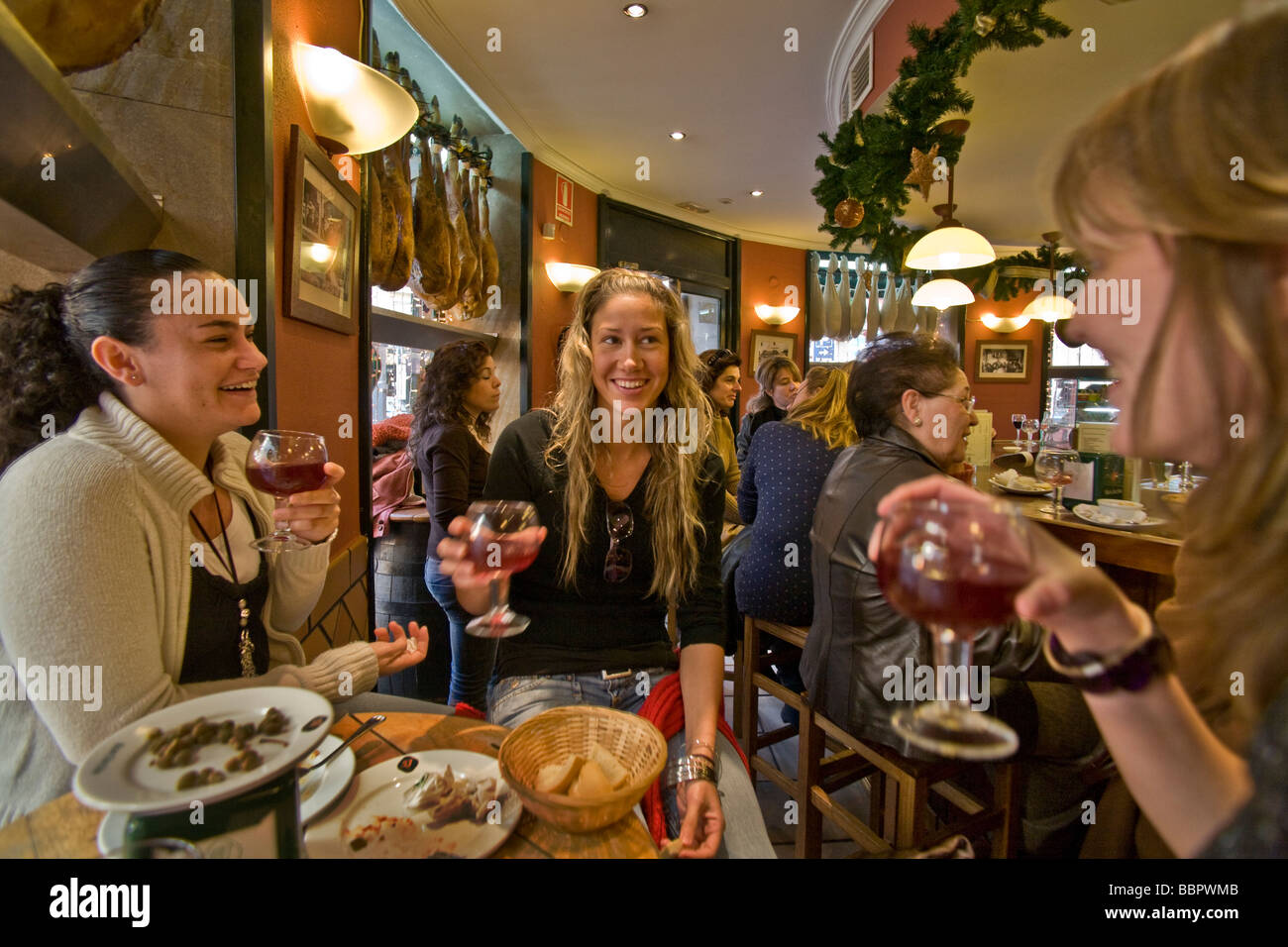 Tre giovani donne converse dopo un pranzo di tapas in un bar nel centro commerciale del quartiere di Siviglia Spagna Foto Stock