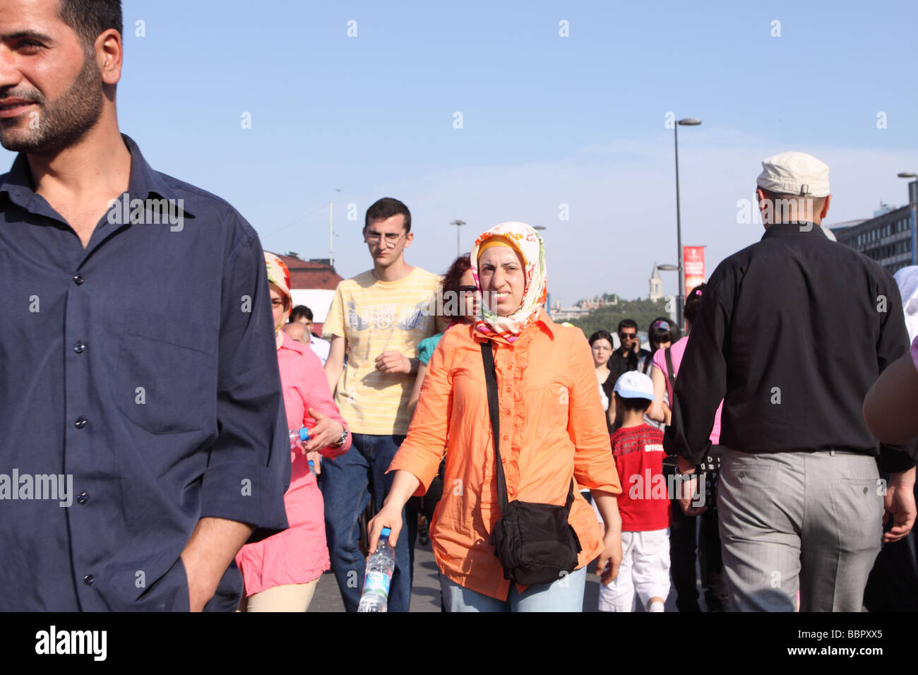 Istanbul Turchia strada trafficata scena con bagno turco donna che indossa velo musulmano tra uomini a Eminonu Foto Stock