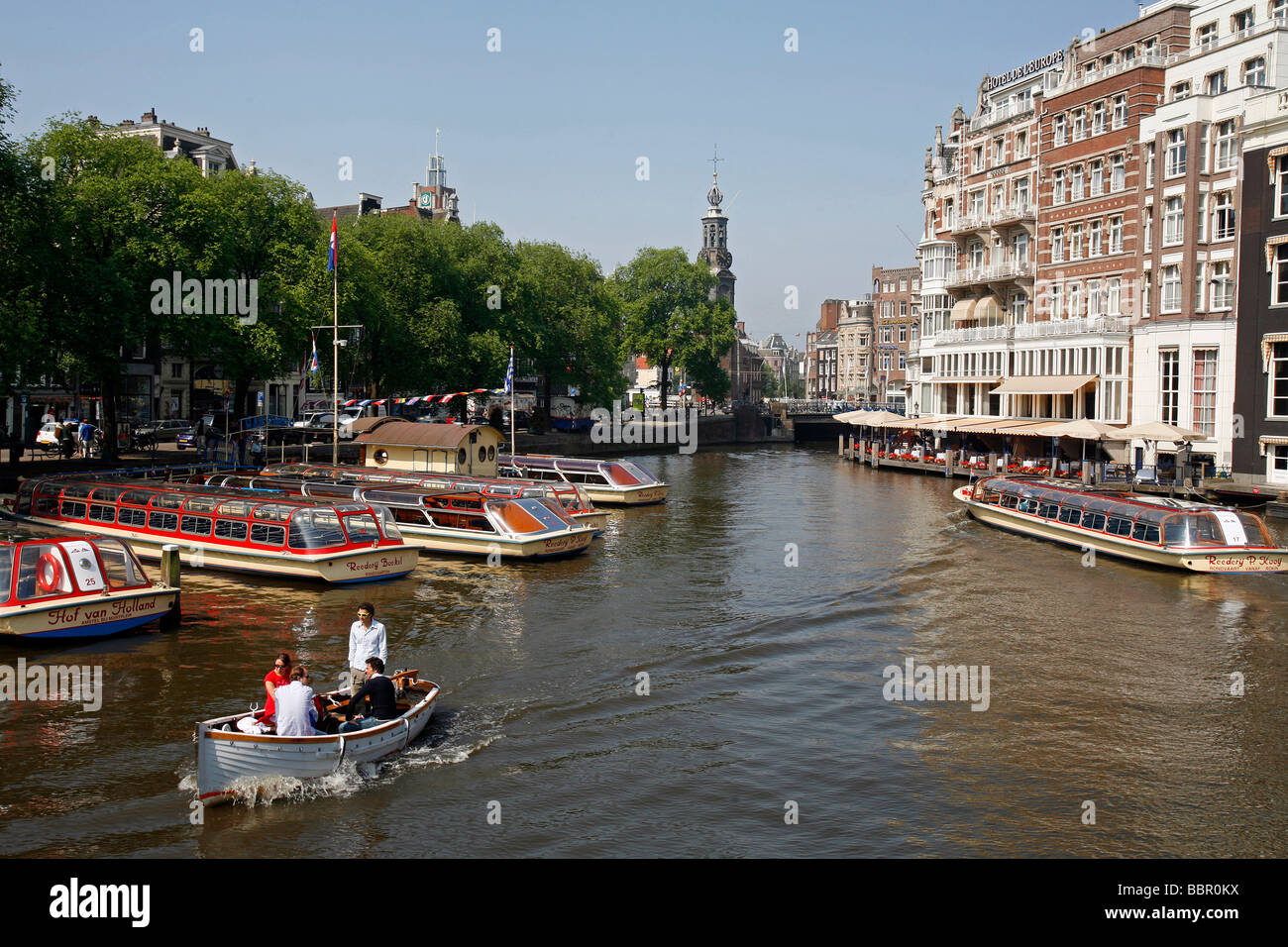 Le imbarcazioni turistiche sul fiume Amstel, facciate di edifici Foto Stock